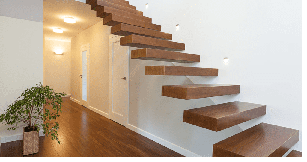 Angled view of modern staircase extending to a second floor next to a lit hallway