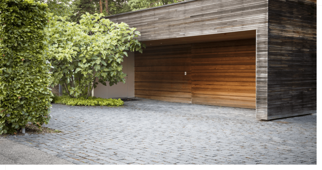Image of exterior of detached building with plants and driveway pavers