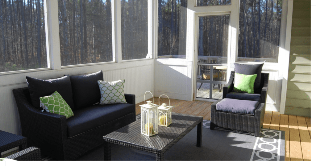 Interior view of a sunroom with patio furniture and an area rug