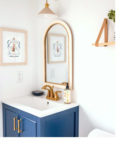 Single blue vanity with mirror and gold fixtures