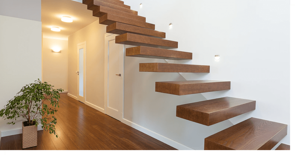 Angled view of modern staircase extending to a second floor next to a lit hallway