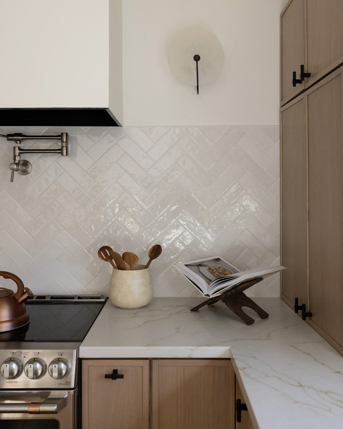 Herringbone tile backsplash behind a slim shaker kitchen