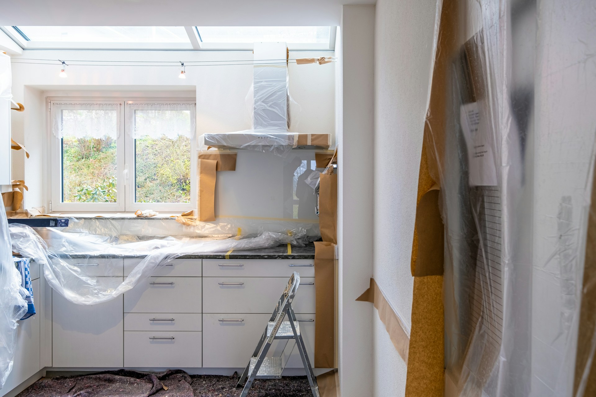 Sunlit kitchen mid-renovation with construction materials.