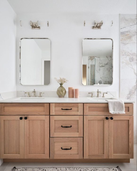 Custom bathroom renovation with wood vanity and oversized mirror