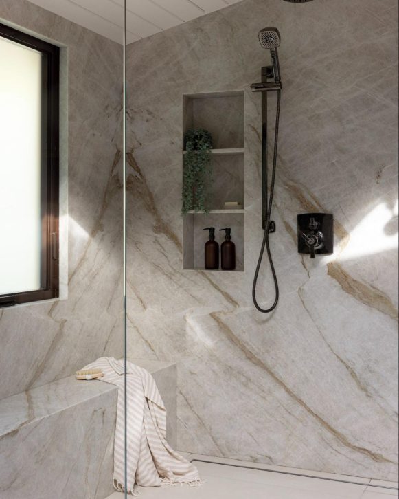 Luxury bathroom shower with natural stone walls and a built-in bench