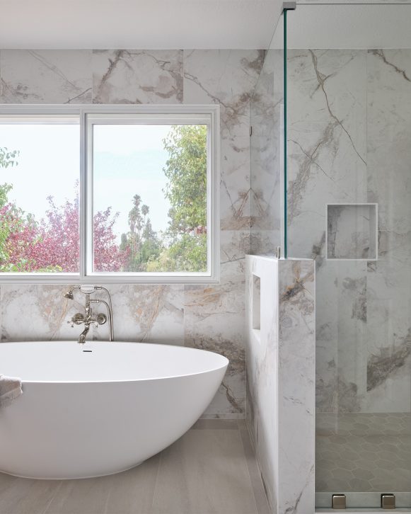 Walk-in shower with green herringbone tile and built-in shower niche